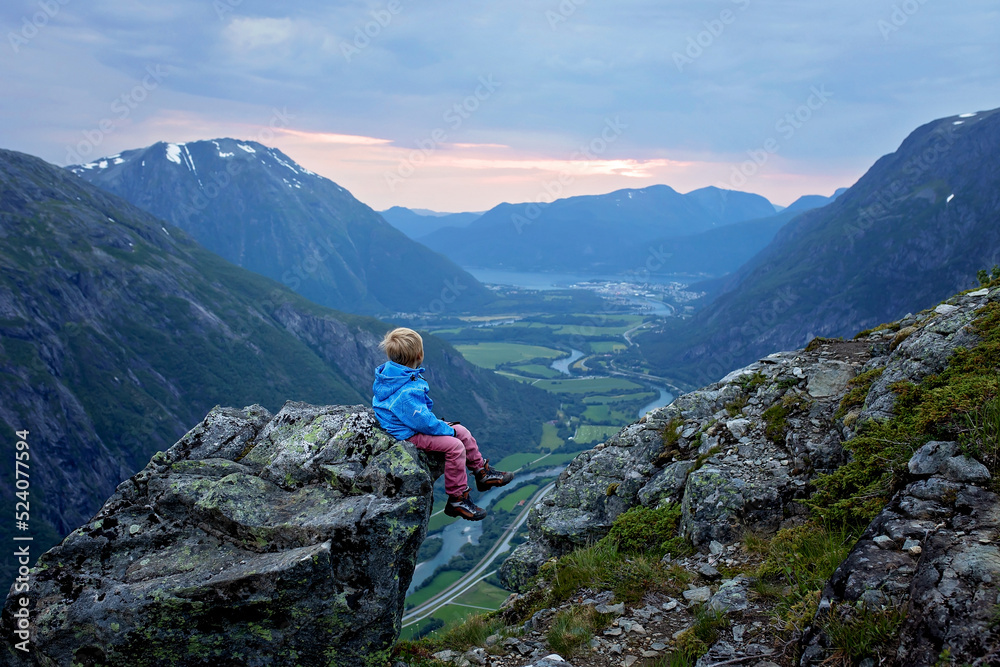 Family with children and dog, hiking in Litlefjellet on sunset, enjoying amazing view from the top of hiking trail