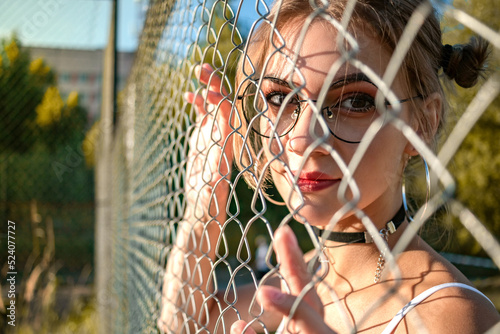 A young girl behind a mesh fence.