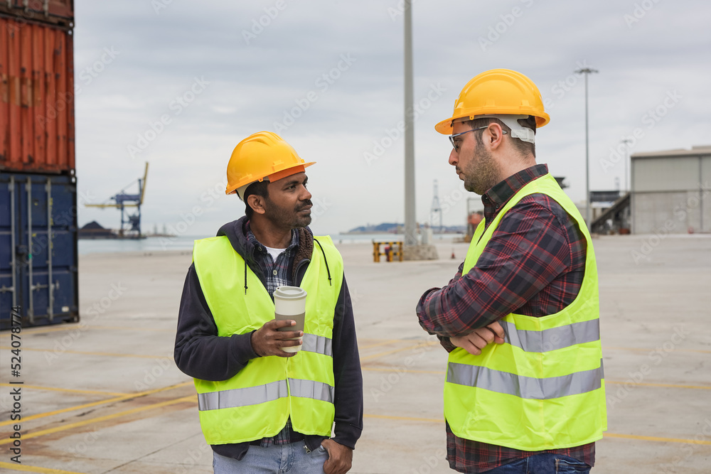 Multiethnic men talking together while standing on a commercial dock