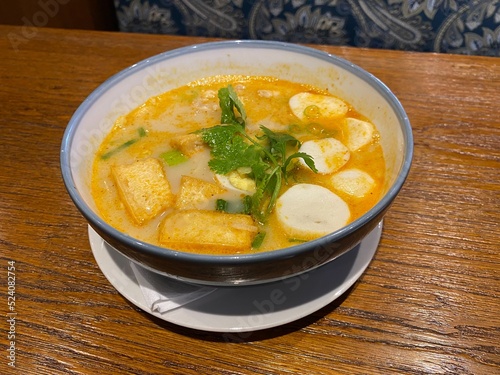Laksa Soup, Indonesia, Asian Food served on a plate with celery, and wooden table background
