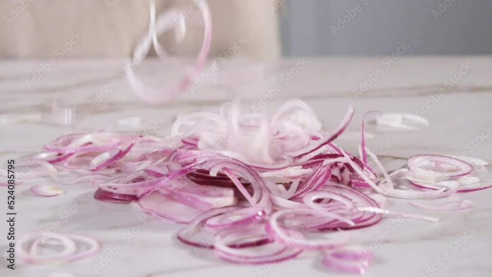 mixing sliced red onions on kitchen counter mixing sliced red onions on kitchen counter