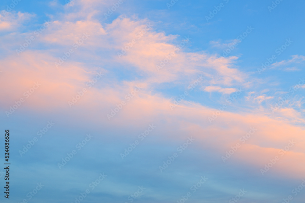 Pink clouds in the blue evening sky. The sky is at sunset.