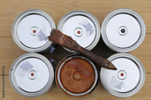 Brush with brown paint on the surface of metal cans with paint - brown alkyd enamel. photo
