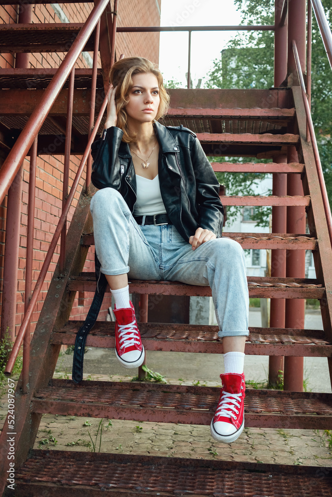 Beautiful girl on the stairs of a brick building. Beautiful girl on the stairs of a brick building.