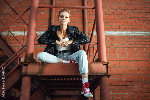Beautiful girl on the stairs of a brick building.