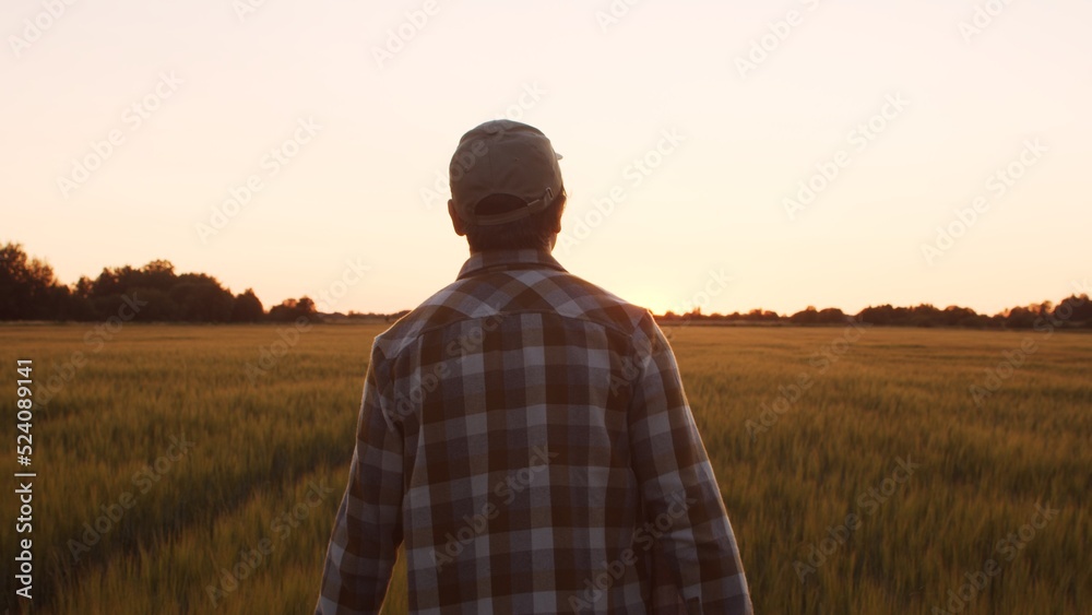 Farmer in front of a sunset agricultural landscape. Man in a countryside field. Country life, food production, farming and country lifestyle concept. Farmer in front of a sunset agricultural landscape. Man in a countryside field. Country life, food production, farming and country lifestyle concept.