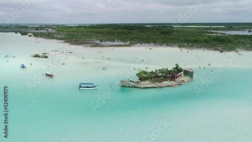 Amazing green island in the middle turquoise milky ocean water with boats around.. photo