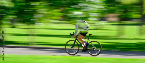 Person Riding Bike Bicycle in Green Park Blurred Speed Blurry Fast