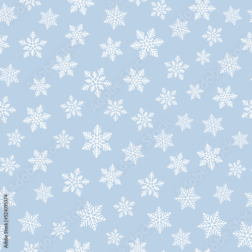 White snowflakes on pastel blue background seamless pattern. Best for textile, wallpapers, wrapping paper and seasonal decoration.