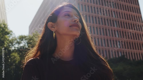 Businesswoman using mobile phone on street in sun