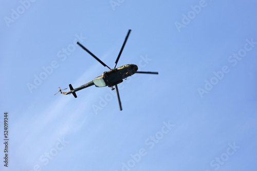 Russian military helicopter Mi-8  NATO codification  Hip  in flight on blue sky background  bottom view