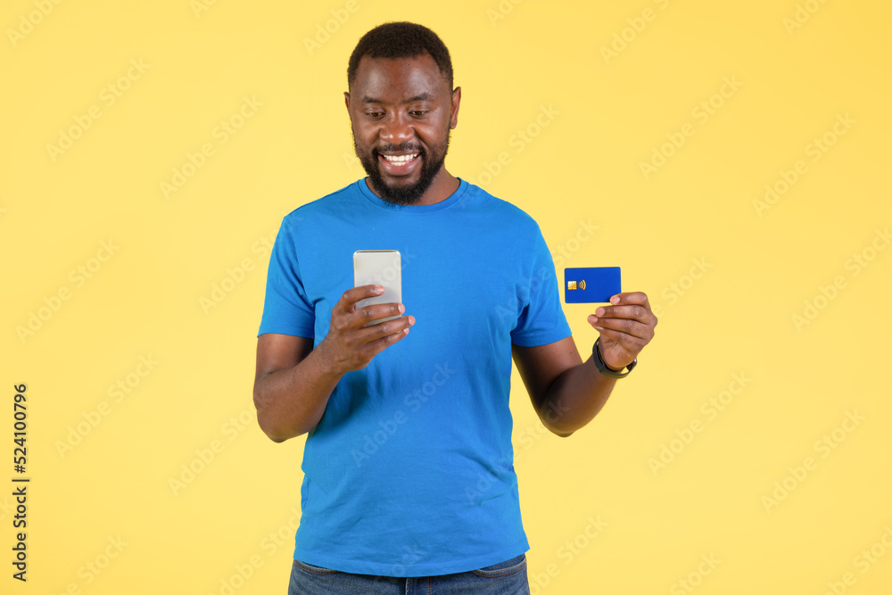 Black Male Using Phone And Credit Card Making Payment, Studio Black Male Using Phone And Credit Card Making Payment, Studio