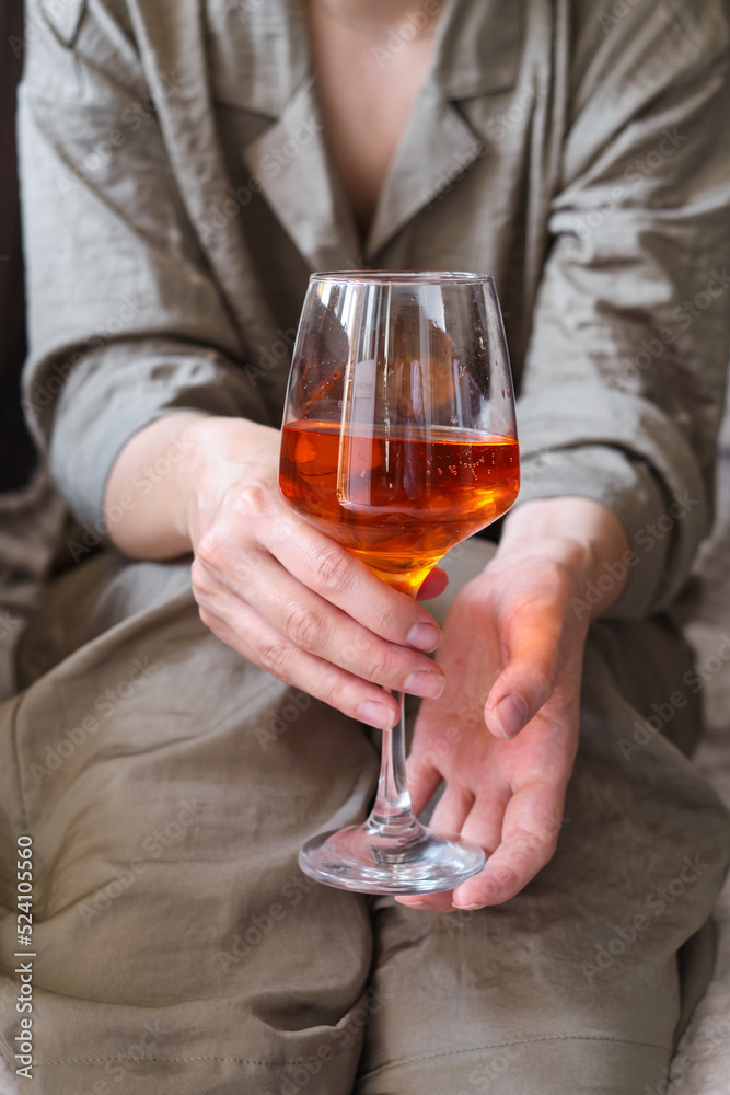 A glass of wine, aperol in the hands of a woman resting at home Tasting alcoholic beverages. Romantic evening aperitif. Close-up of a glass of wine. Enjoy the moment A glass of wine, aperol in the hands of a woman resting at home Tasting alcoholic beverages. Romantic evening aperitif. Close-up of a glass of wine. Enjoy the moment