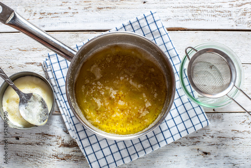 Step-by-step preparation of homemade ghee (ghee), step 3 - after a long languishing, the foam and sediment are removed, horizontal photo