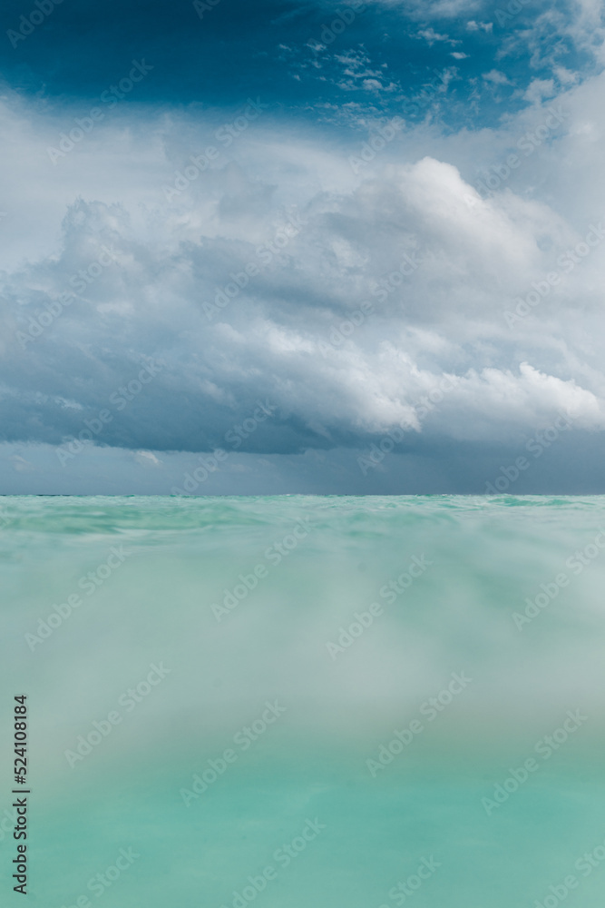 nubes de tormenta en una playa de agua cristalina en Islas Maldivas