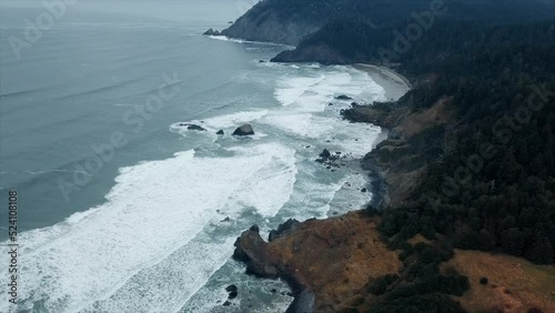 Aerial shot over stormy coast with waves crashing