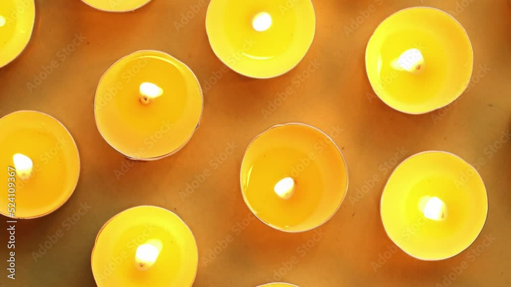Yellow candles on an orange background, top view, romantic pattern. Yellow candles on an orange background, top view, romantic pattern.