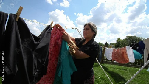 Woman Using Clothe Lines To Dry Clothes In an Energy Efficient Way