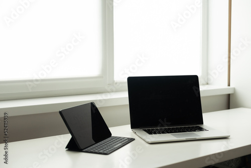 laptop and tablet on a white table