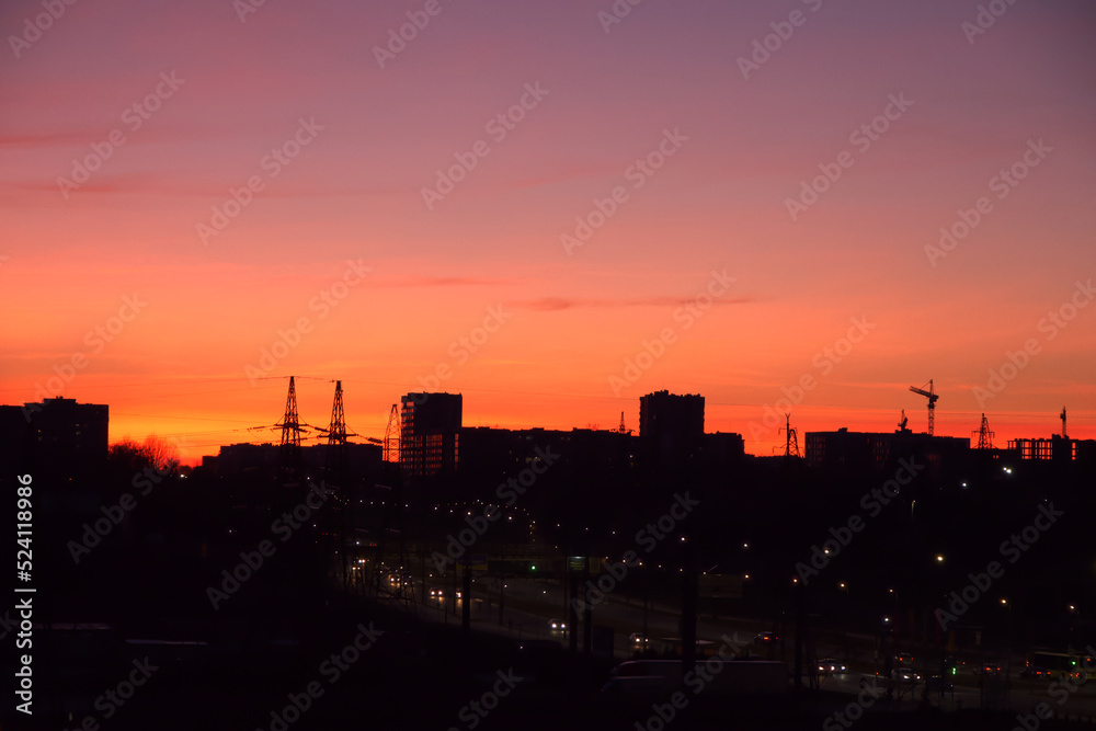 Bright dawn over the city, colorful sky over the houses early in the morning