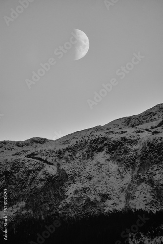 Moon rising above mountain on Godøy in winter, Sunnmøre, Møre og Romsdal, Norway.