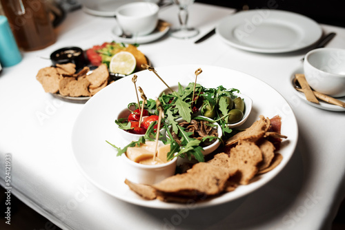 assorted cheese, olives, tomato and croutons on a plate