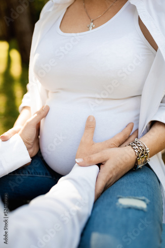 man and woman hands hugging pregnant belly