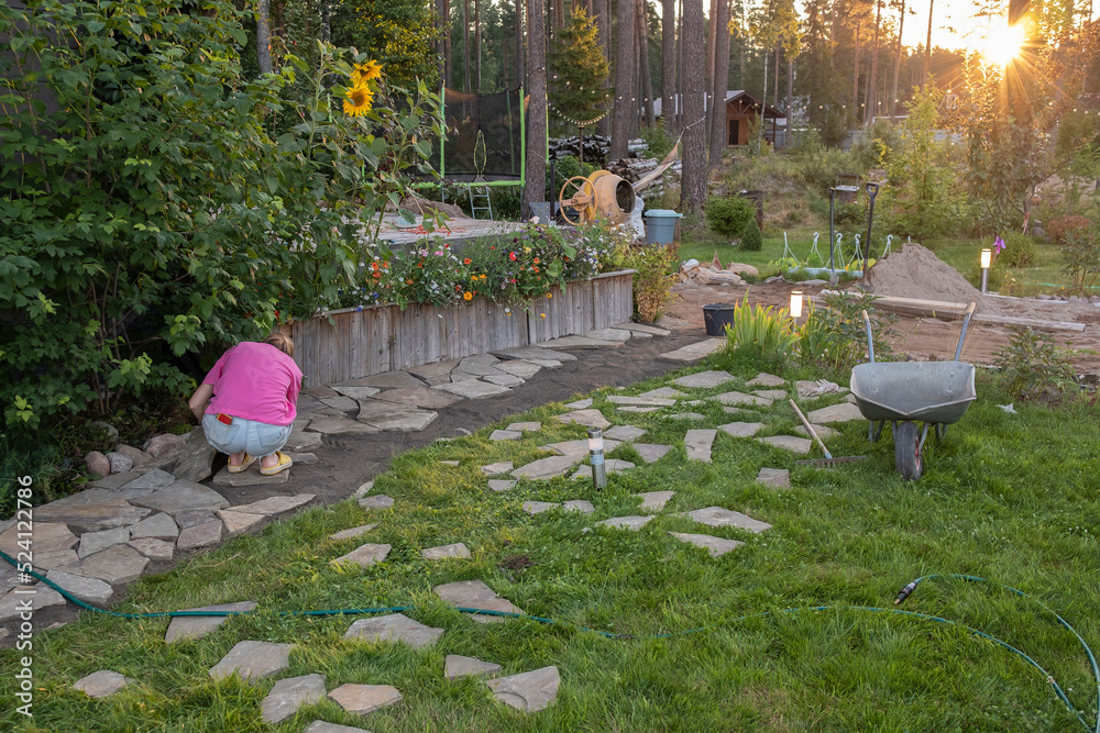 Foto de girl builder laying and grouting York stone paving slabs