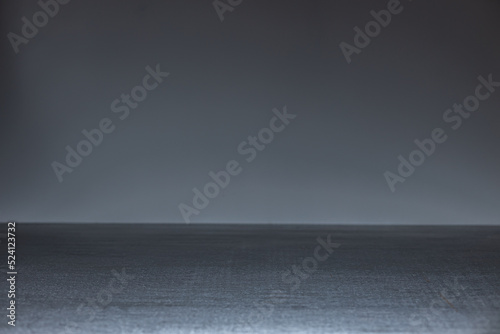 An empty dark table on a gray background