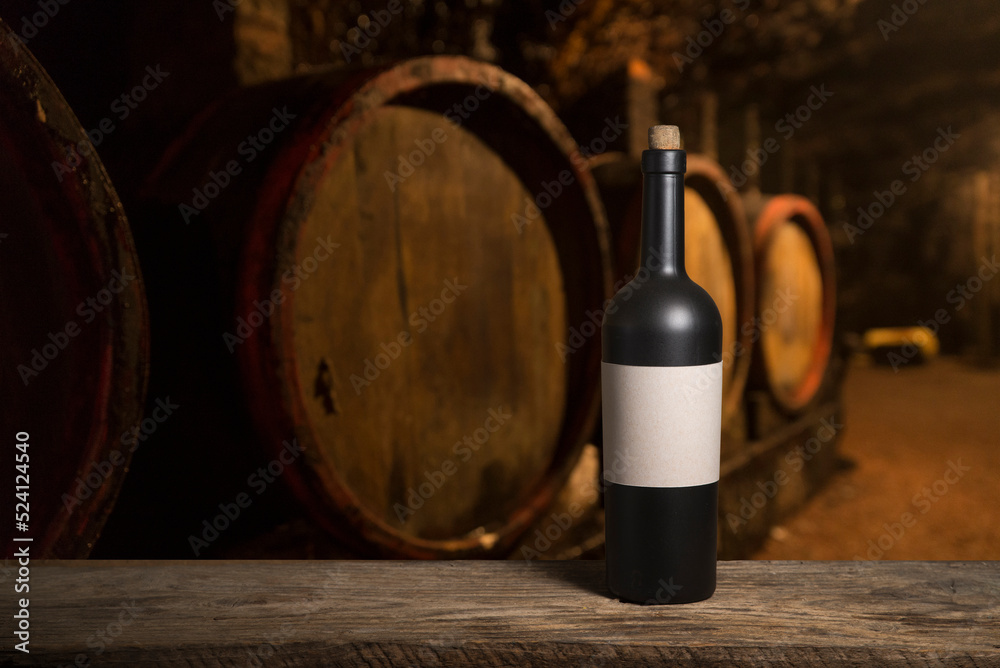 Pouring red wine into the glass against wooden background