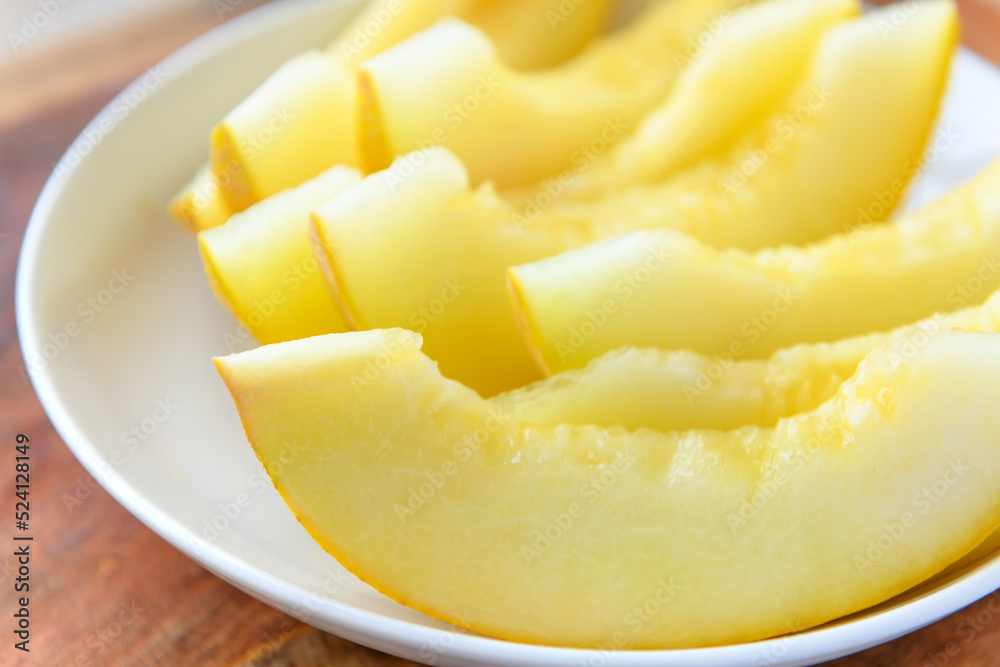 a plate full of sliced melon on a wooden board, the concept of fresh fruit and healthy food