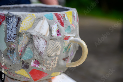 Homemade mosaic flower pot with porcelain pieces. Recycling, broken tableware, ceramics, crafts, mosaics.