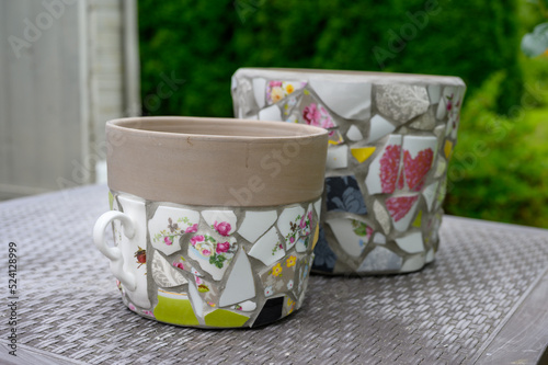Homemade mosaic flower pot with porcelain pieces. Recycling, broken tableware, ceramics, crafts, mosaics.