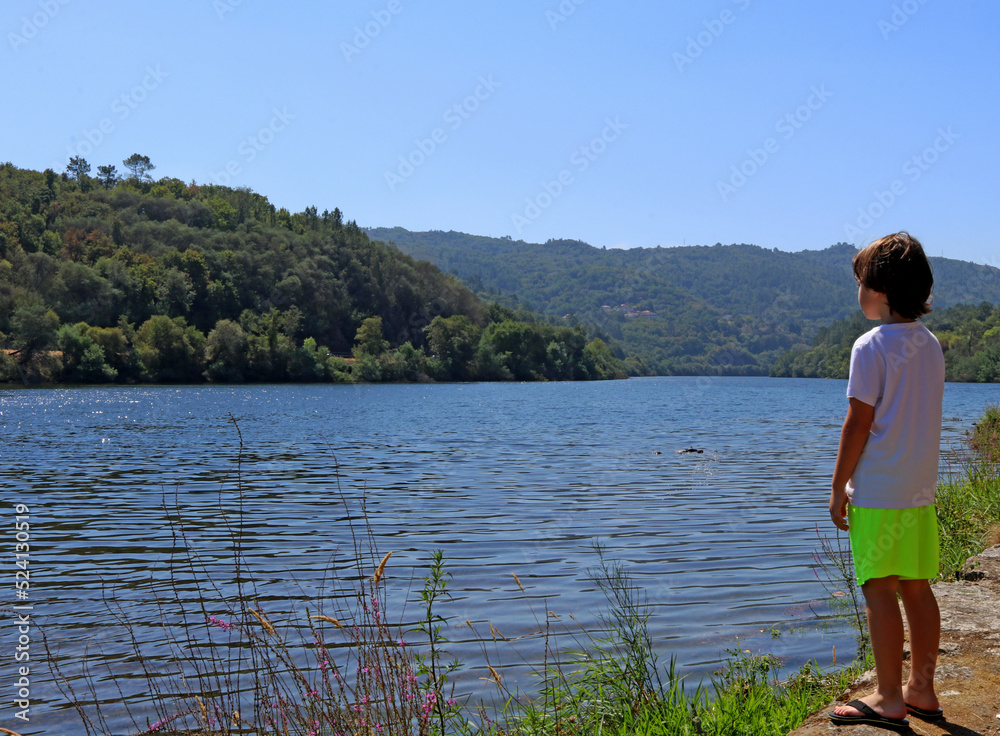 Child on the shore of a lake