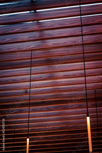 Ceiling with wooden slats and cylindrical lights