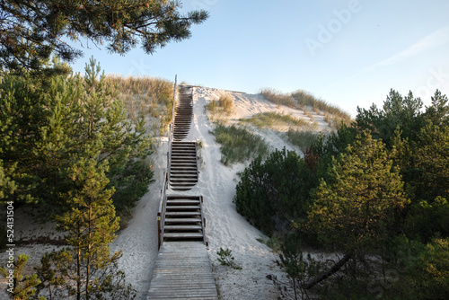 Wooden stairs to the beach covered with sand. Lubiatowo dunes, nature park with a protected coastal strip by Baltic sea.