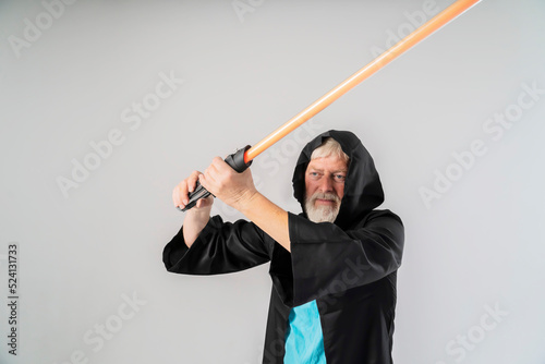 Obraz na płótnie a man holds a lightsaber in a Halloween costume on a white background