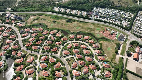 Vacation bungalow park accomodation leisure resort in Zeeland, The Netherlands. Summer cabin village on the sea side. Summer cottage overhead drone aerial to spend holidays.