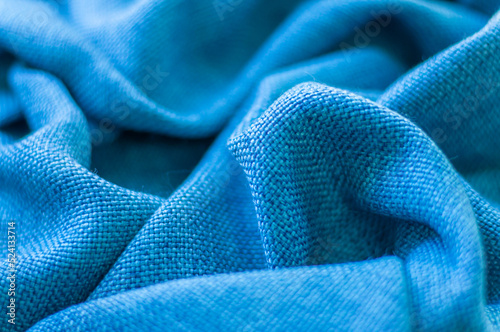 Natural blue wrinkled cotton fabric. Woven fabric background. Closeup