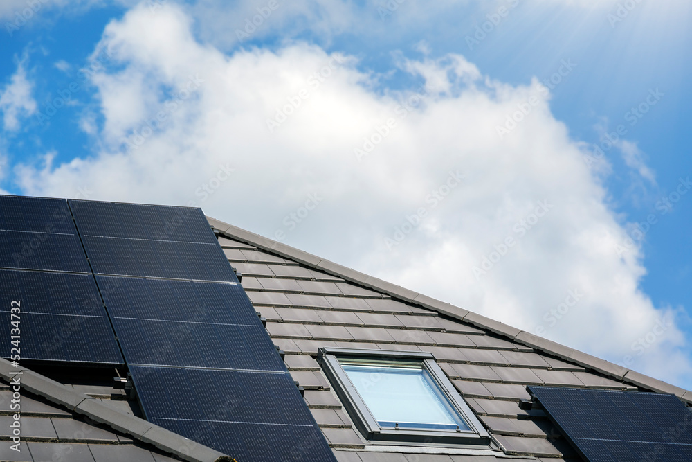 Fototapeta premium Solar panels on the house roof in sunny day. Renewable clean green energy generation.
