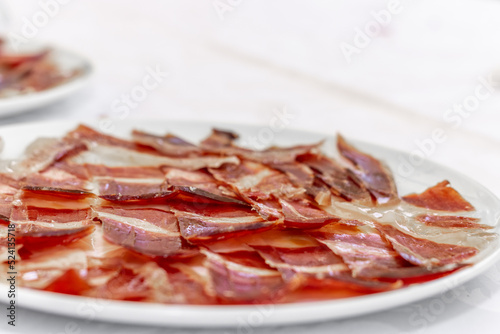 Close-up of a plate of iberian ham on a white plate. Typical spanish food. Selective focus