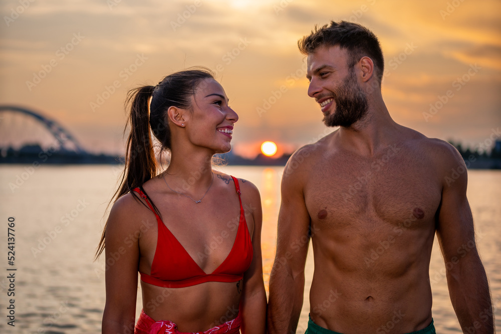 Couple in love having romantic tender moments at sunset on the beach - Young lovers having tender moments in summer vacation - Love concept. Selective focus