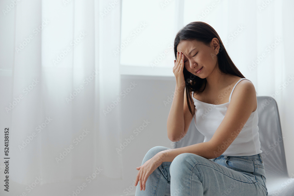 SARS CoVID symptoms. Tormented tanned beautiful young Asian lady touching forehead feel elevated temperatures at home interior living room. Injuries Poor health Illness concept. Cool offer Banner SARS CoVID symptoms. Tormented tanned beautiful young Asian lady touching forehead feel elevated temperatures at home interior living room. Injuries Poor health Illness concept. Cool offer Banner