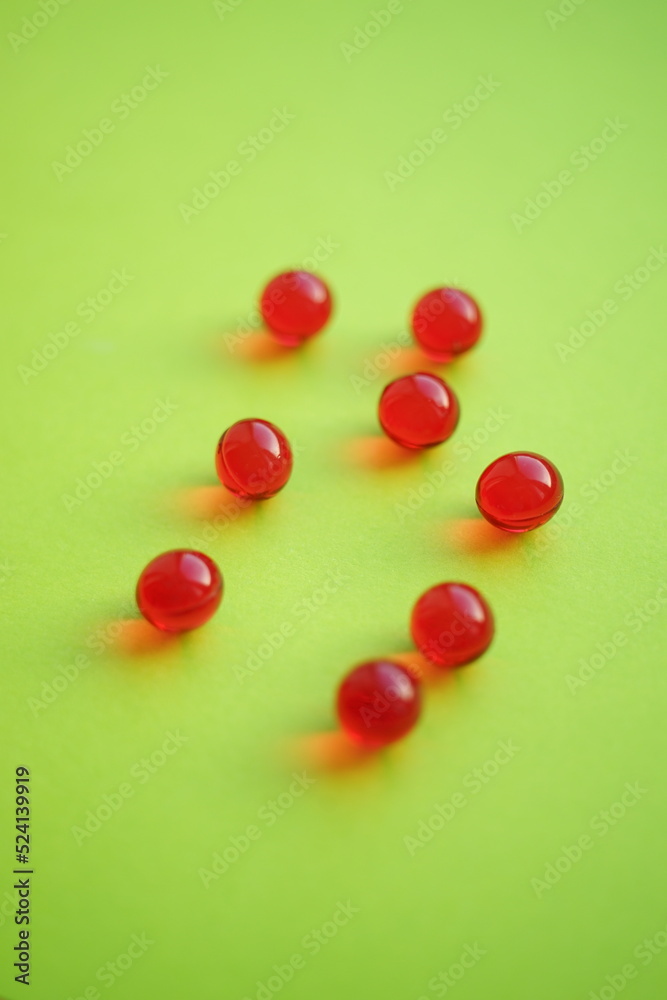 Obraz premium Round red vitamins on a green table