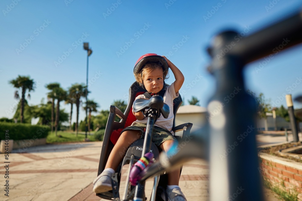Obraz premium cute little boy with big bike outdoors in city street. High quality photo
