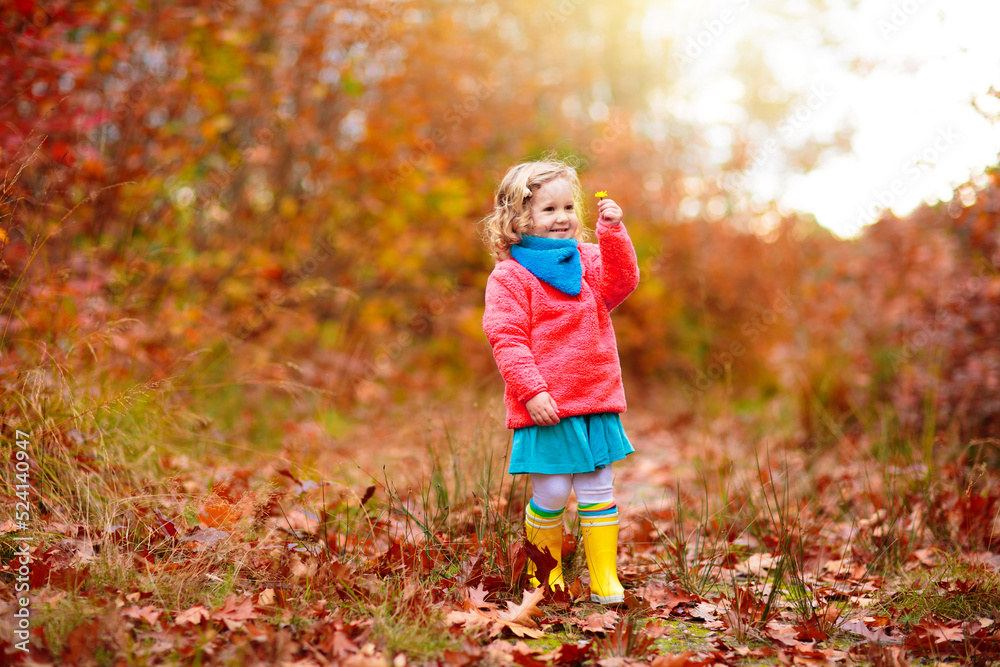 Kids play in autumn park. Children in fall forest.