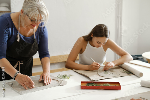 Wallpaper Mural Pottery workshop in studio. People working with clay on the table. Adults learning to do ceramic plates. Pottery as hobby and leisure activity Torontodigital.ca