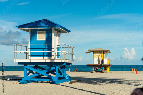 Lifeguard house on Hollywood beach in Florida, clean sand with ocean and blue sky in the background.