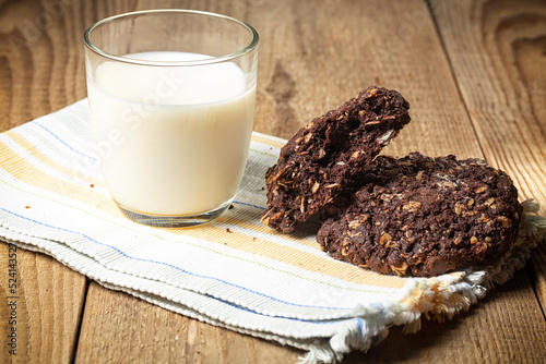 chocolate oatmeal coolies and glass of milk on woden table. photo