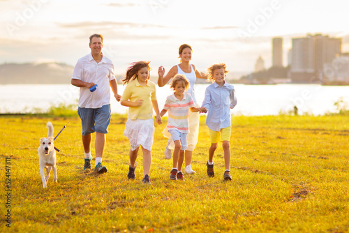 Family with kids running outdoor at sunset.